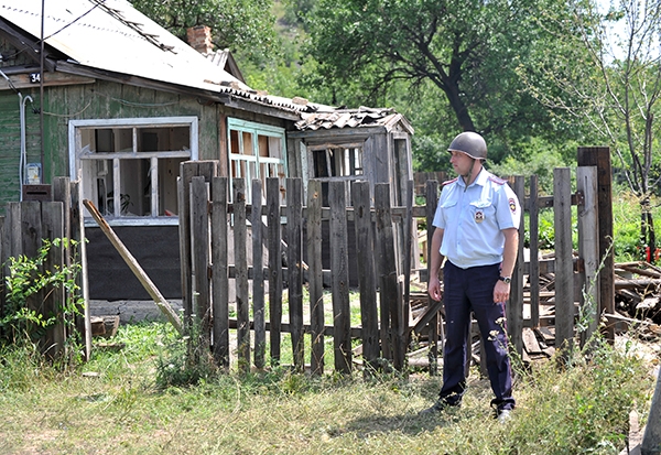 Сотрудники правоохранительных органов работают на месте попадания одного из фугасных снарядов в городе Донецке Ростовской области со стороны украинской территории.
